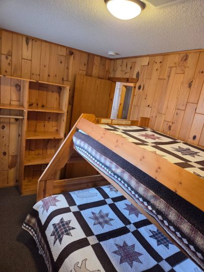 Rustic cabin bedroom with wooden bunk beds and star quilts