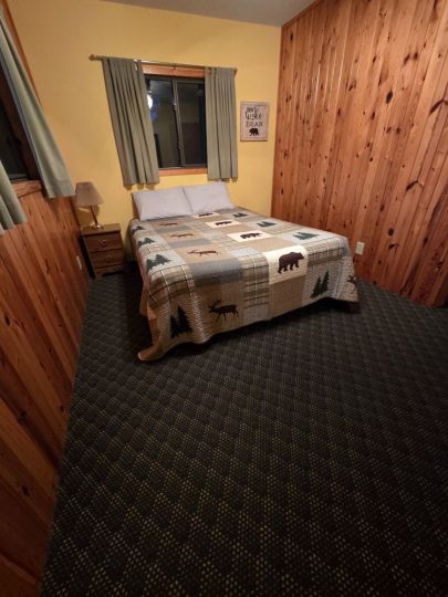Cozy rustic cabin bedroom with wildlife-themed quilt