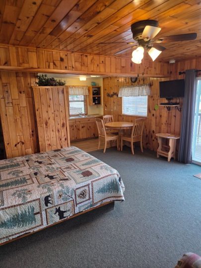 Cozy rustic cabin interior with woodland quilt and wood paneling