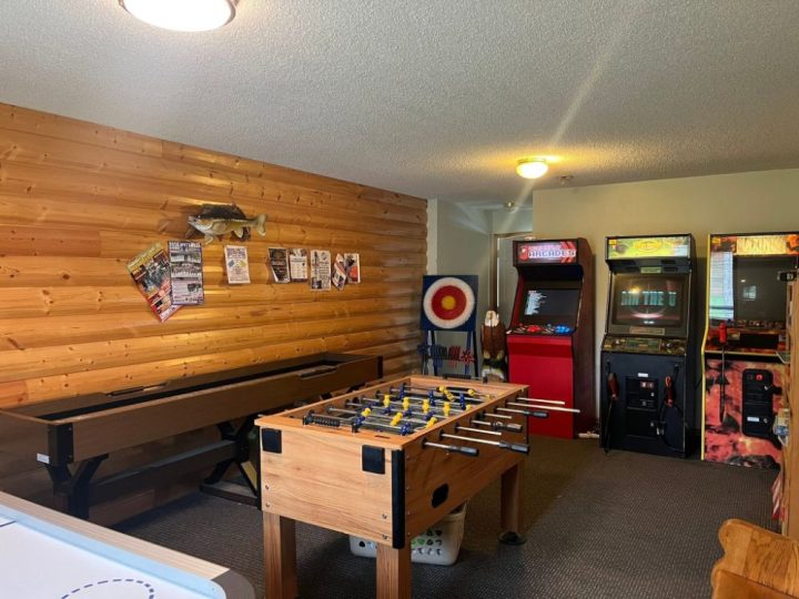 Rustic game room with foosball table and arcade machines